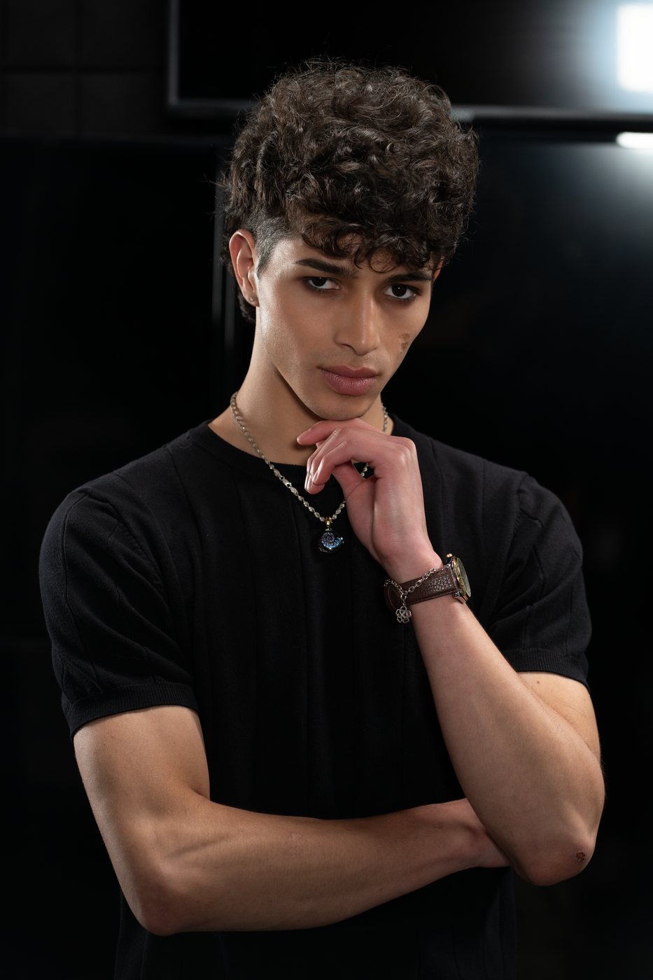 Editorial grooming and skin prep on a male model in a dark studio
