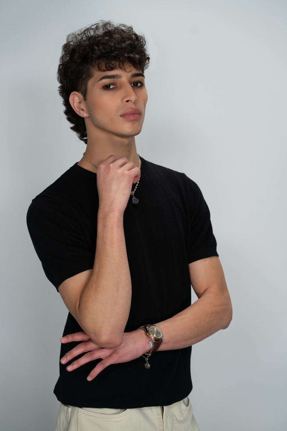 Clean editorial makeup on a male model against a light backdrop