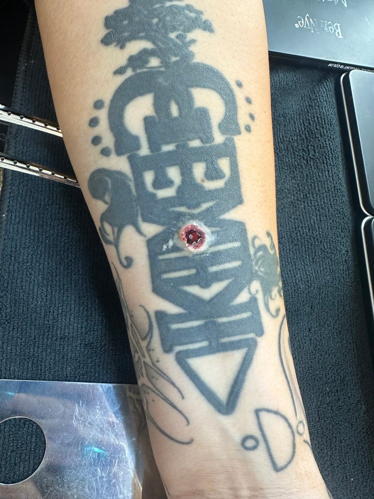 Simulated bullet entry wound applied over an existing tattoo